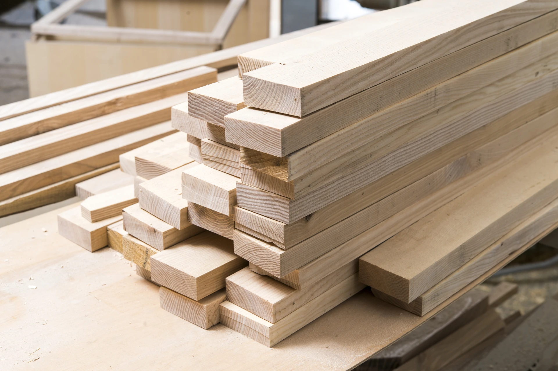 Atelier menuiserie intérieur avec planches de bois empilées sur établi
